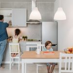 A father and children enjoying quality time in a bright, modern kitchen area.
